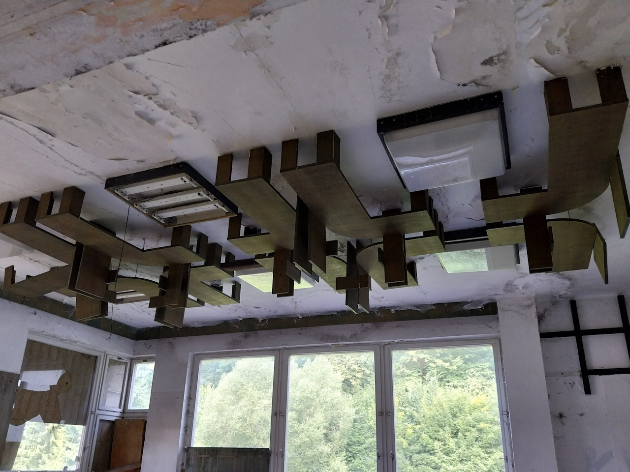 Dřevěné obložení kolem světel v hlavní budově. Právě zde se nám odkrývá architektura období socialismu.