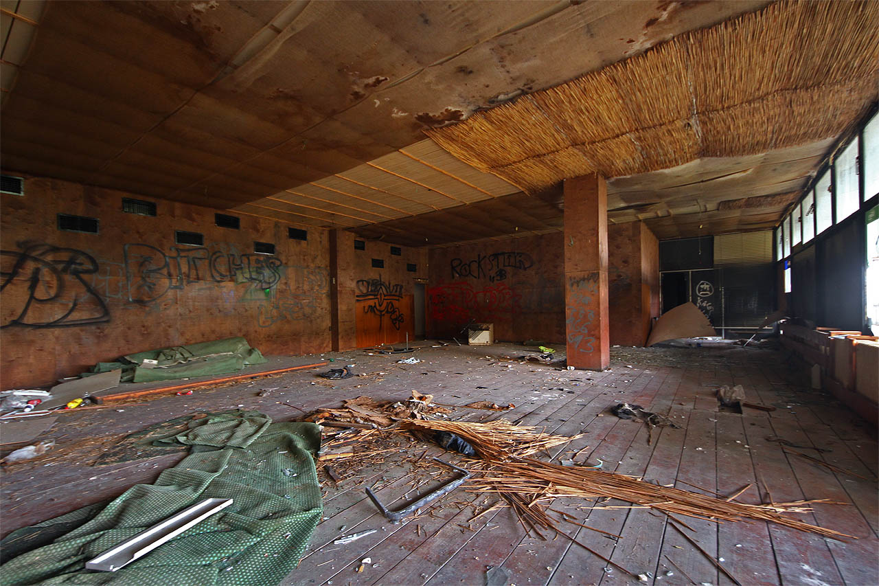 Marno soudit, proč poslední provozovatel restaurace pobil betonové stropy a stěny překližkou a rákosovými rohožemi. Snad aby získala socialistická hospoda vzhled karibského bungalovu?