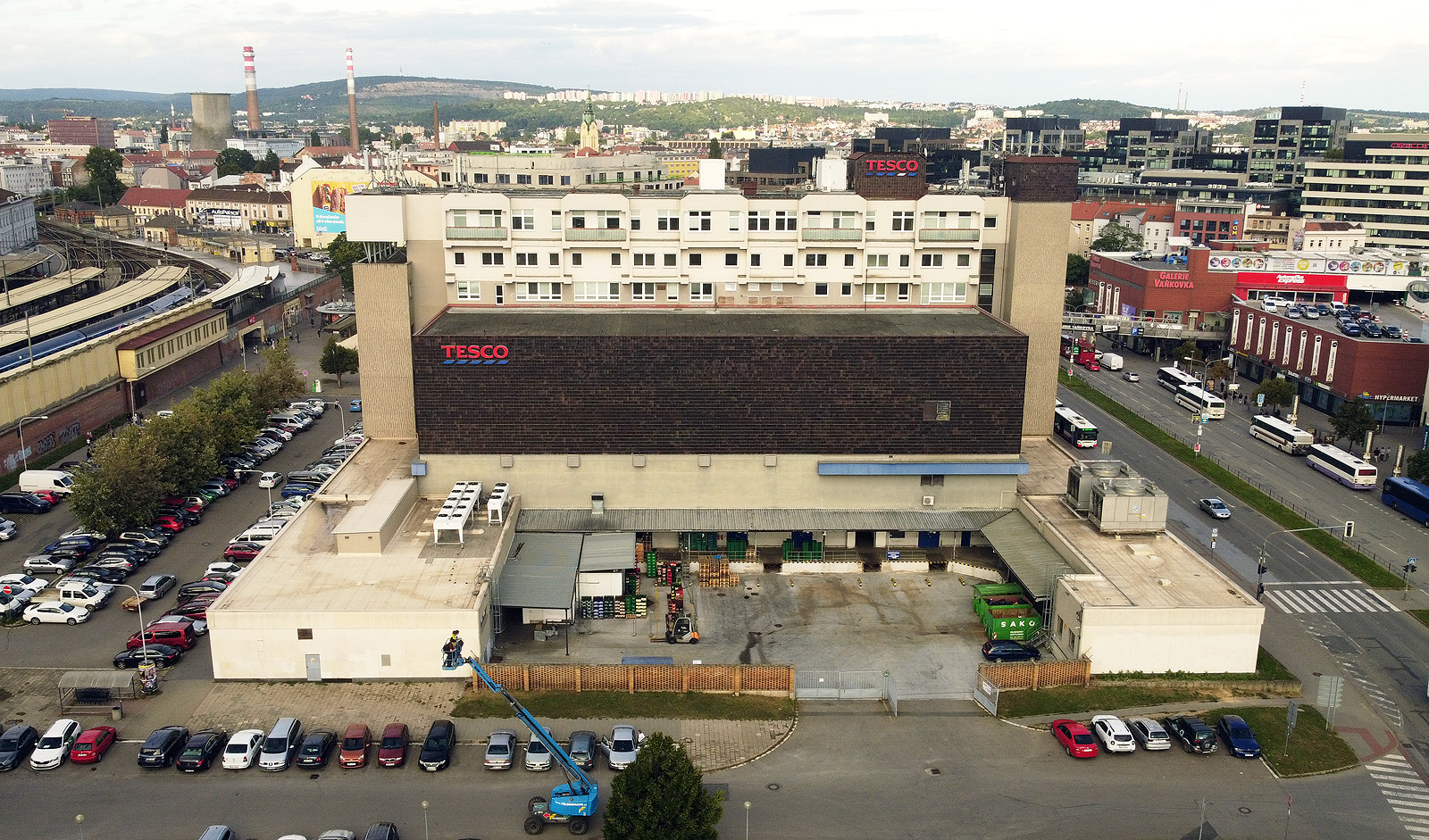 Pohled na obchodní dům od jihu. K hlavnímu kvádru byla dodatečně přistavěna dvě přízemní křídla, která uzavírají nevelký manipulační dvůr.