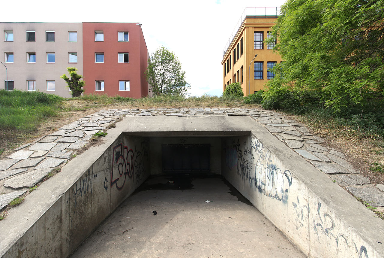 Betonová tlama neomylně zve ke vstupu každého, komu v žilách koluje romantická krev. Stačí nadzvednout docela lehkou plastovou klapku (nedělaly se dřív tyhle klapky z litiny?).