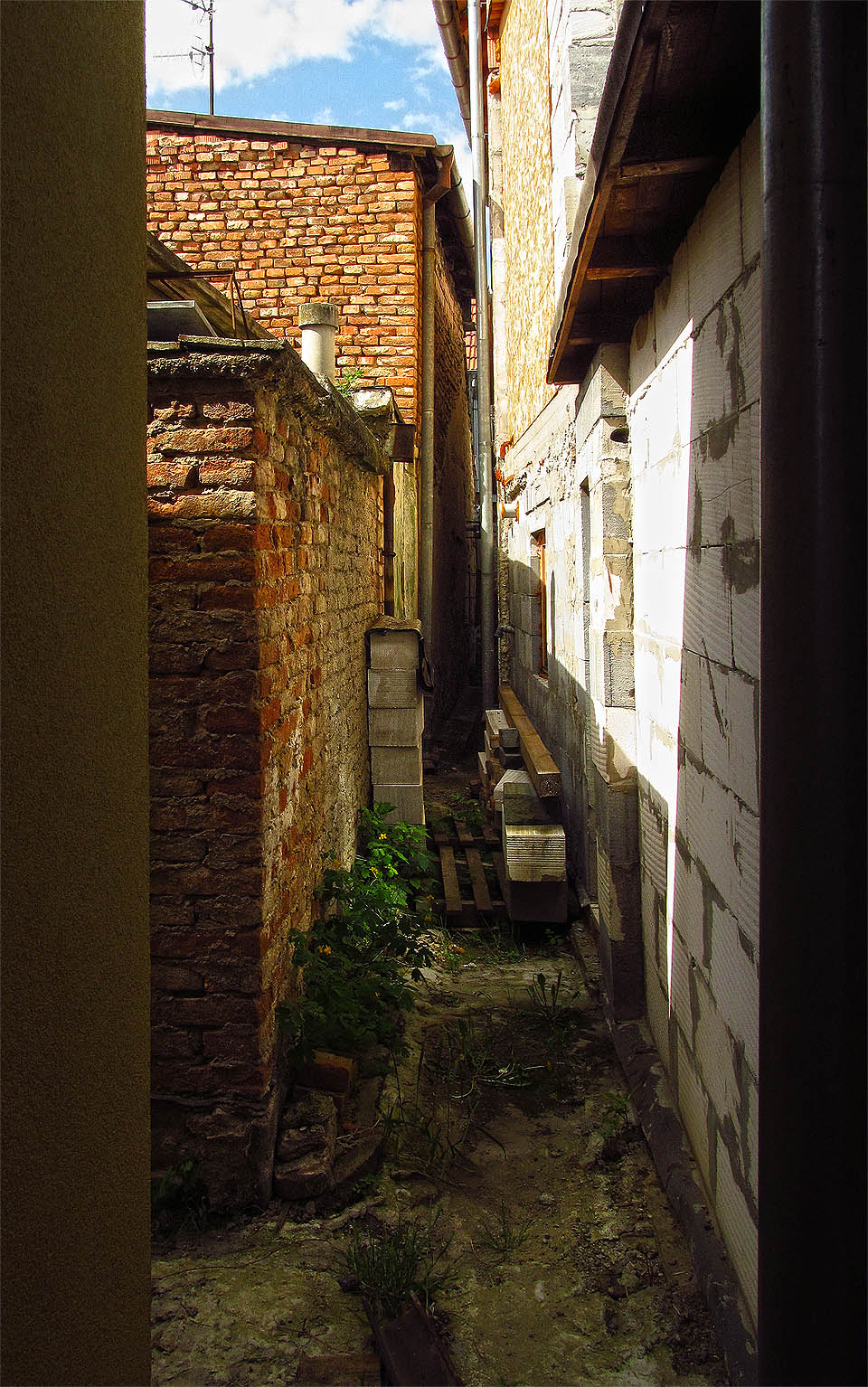 Nejužší průchod je několikrát zalomenou uličkou mezi zadními trakty domků.