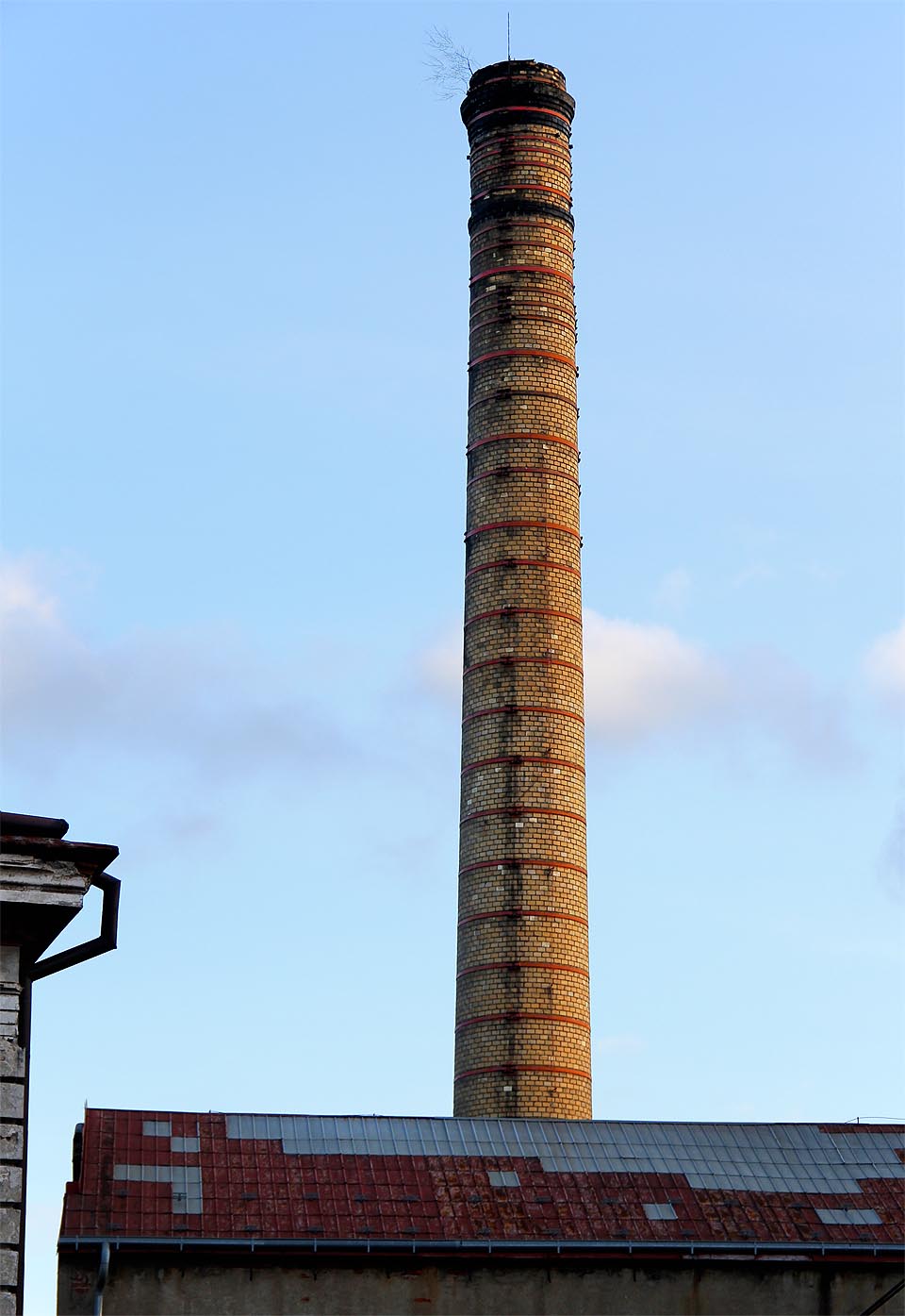 Elegantní šamotový komín je omšelou chloubou papírny na břehu řeky Bělé.