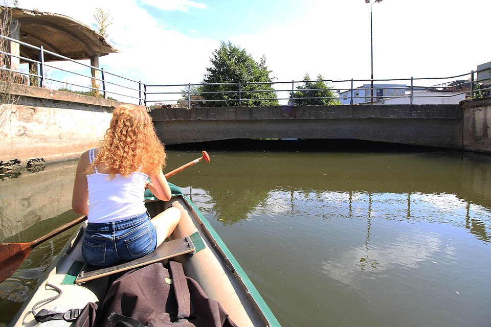 Abychom se dostali z těsného koryta náhonu, sevřeného mezi betonovými zdmi, musíme podjet most vlečky, který je jen o několik centimetrů vyšší než naše loď. nezbývá než si lehnout a ručkovat prsty po stropě.
