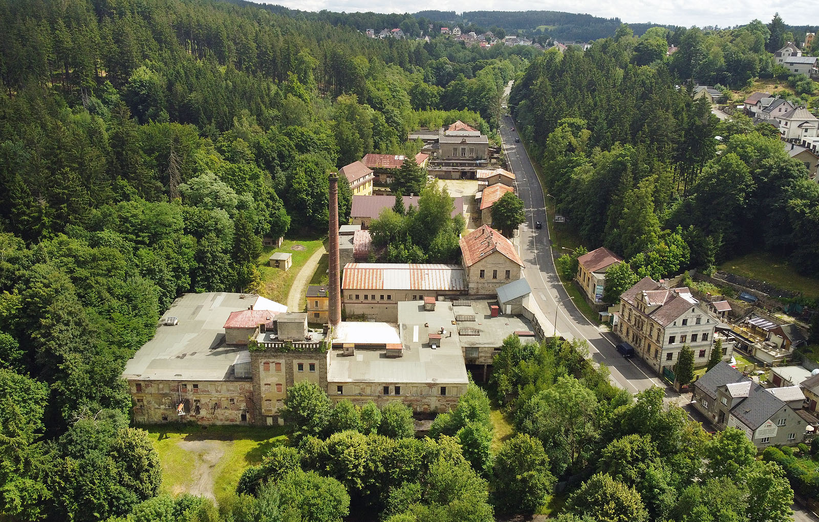 Pohled na pivovar od severu, tedy proti proudu potoka. Dole s cimbuřím nejstarší provoz, později sladovna, výše přistavované objekty, varna, ležácké tanky, sklepy. Vpravo přes silnici je vidět remíza pro nákladní tramvajové vozy, které sloužily pro přepravu surovin a piva po úzkorozchodné tramvajové trati vedené Pražskou ulicí.
