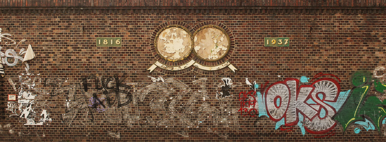 Na obvodové zdi areálu ze strany do ulice Glauchauer Straße se skví jiná dvojice letopočtů. Zatímco rok založení 1816 zůstává, svědčí uliční trakt o době své výstavby těsně před 2. světovou válkou. Otlučené medailony zřejmě neukazují stav zeměkoule po válce, nýbrž kdysi nesly portréty zakladatele a majitele pivovaru.