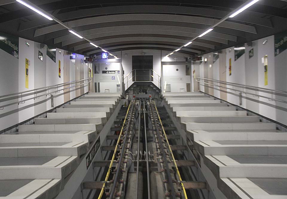 Návštěvnící přístupné, moderní části stanice Parc de Montjuïc netuší, že se ve stejné budově jen o pár metrů výše skrývá opuštěné, smutné a nepřístupné nástupiště druhé části dráhy, která byla zrušena v roce 1981.