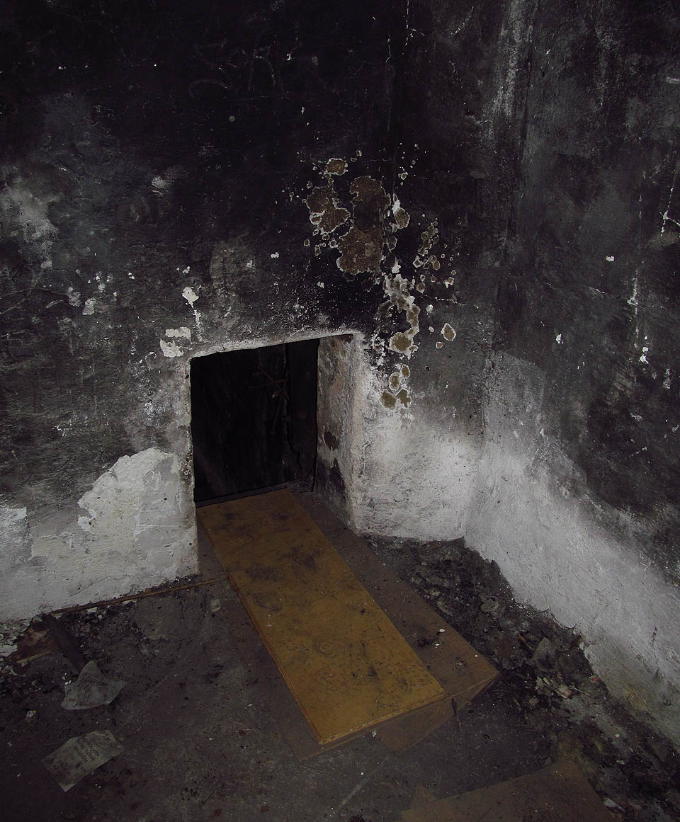 Ze vstupní, nízké místnosti vede miniaturní průlez někam dál…