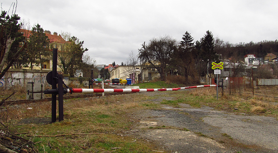 Dřevěné závory na cestě k Waltrovce, před kterými vedla vlečka do strojírny, se v roce 2014 otevíraly ručně a pouze na vyžádání.