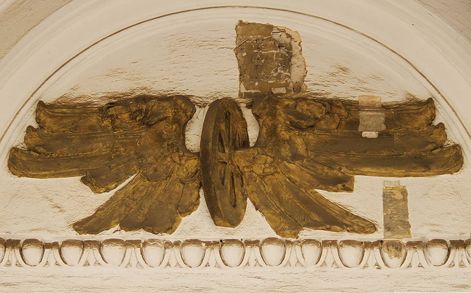 Jako by perutě okřídlených kol nad vchodem jaksi trpěly únavou. Jako by perutě okřídlených kol nad vchodem jaksi trpěly únavou.