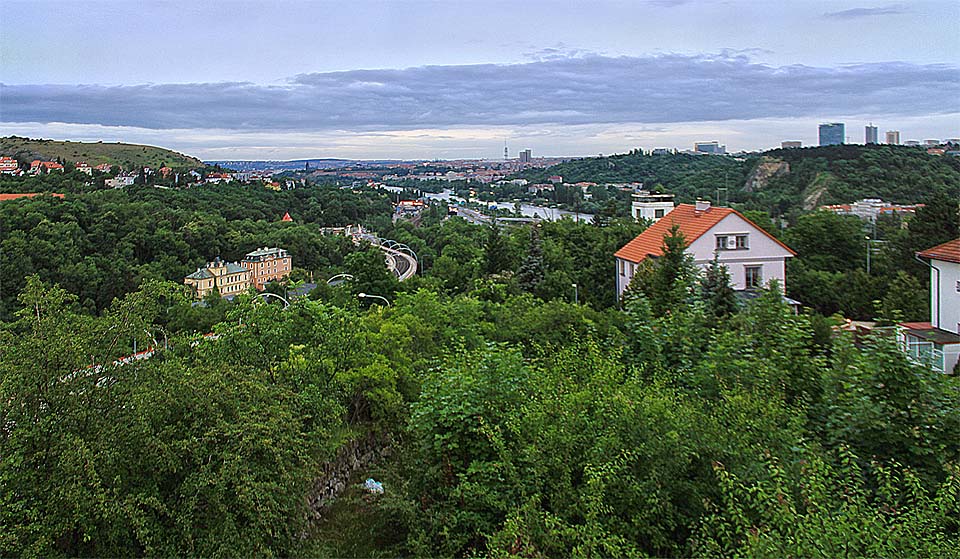 Pohled z okna vily směrem na severovýchod - k centru města na Vltavu a věž pustnoucích Barrandovských teras (za červenou střechou domu v popředí).