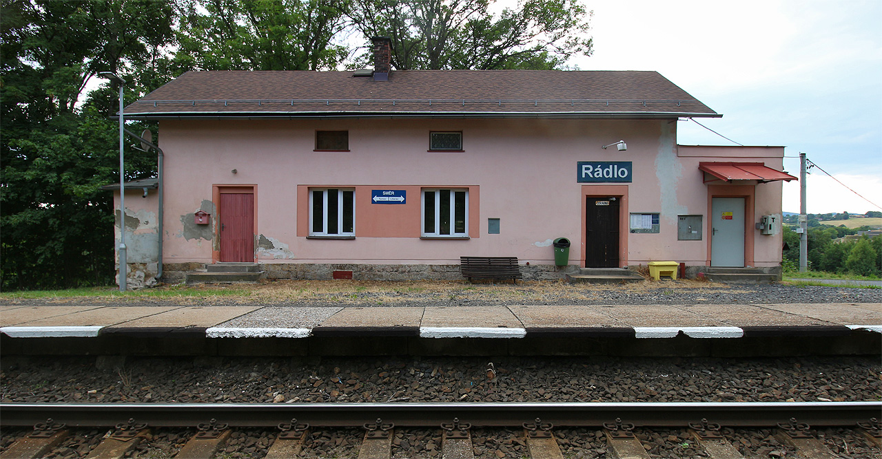 Budova zastávky s čekárnou a přístavbou zabezpečovacího zařízení vpravo a služebním bytem vlevo.