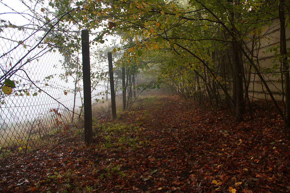 Náhodná podzimní procházka údolím Troubského potoka může člověka přivést až k podivnému plotu a zdi upsotřed lesů. Byl by hřích, nenakouknout dovnitř opuštěného areálu.