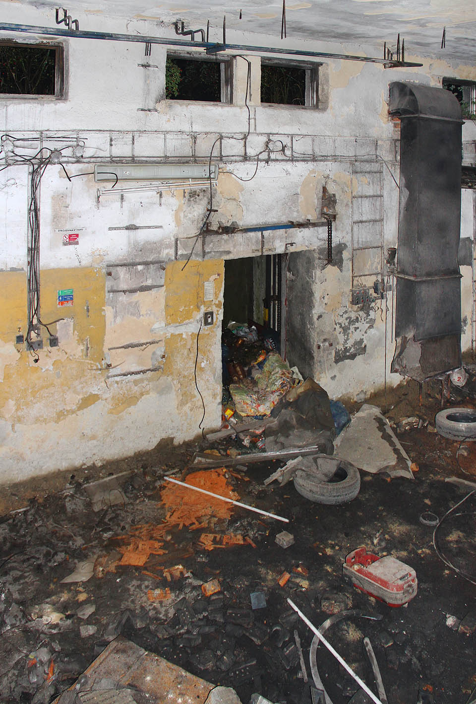 Pohled do kotelny s nákladním výtahem, který místní zasypali komunálním odpadem.