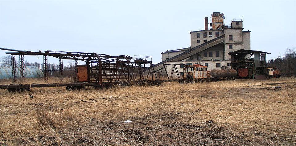 Zátiší s vozem pro vytrhávání kolejnic, opuštěnou továrnou a rezivějícími vozidly je skutečně tiché.