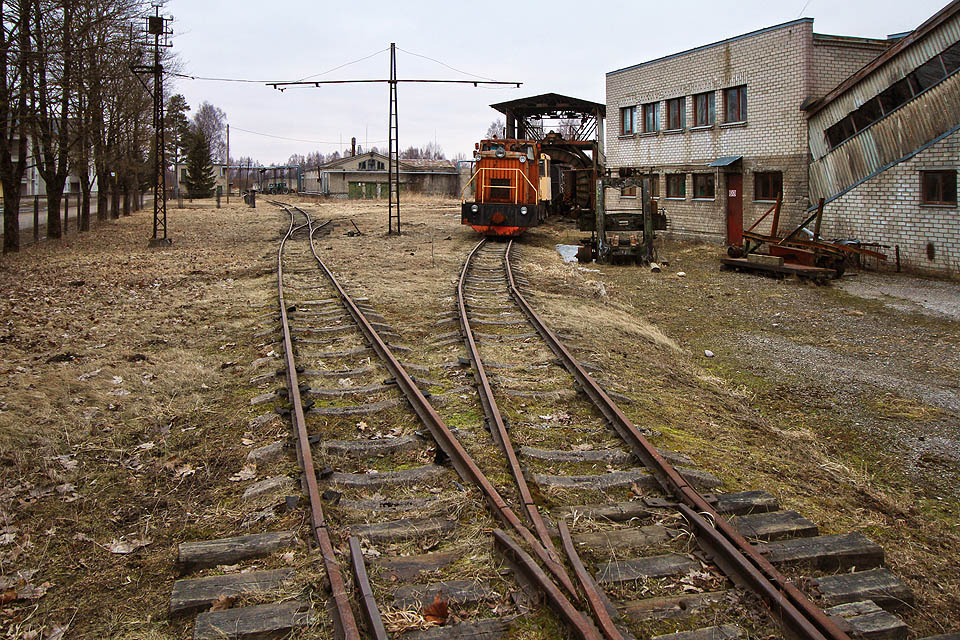Do oploceného areálu lze projít otevřenou branou. Na zbytcích kolejové sítě postává několik úzkokolejných vozidel.