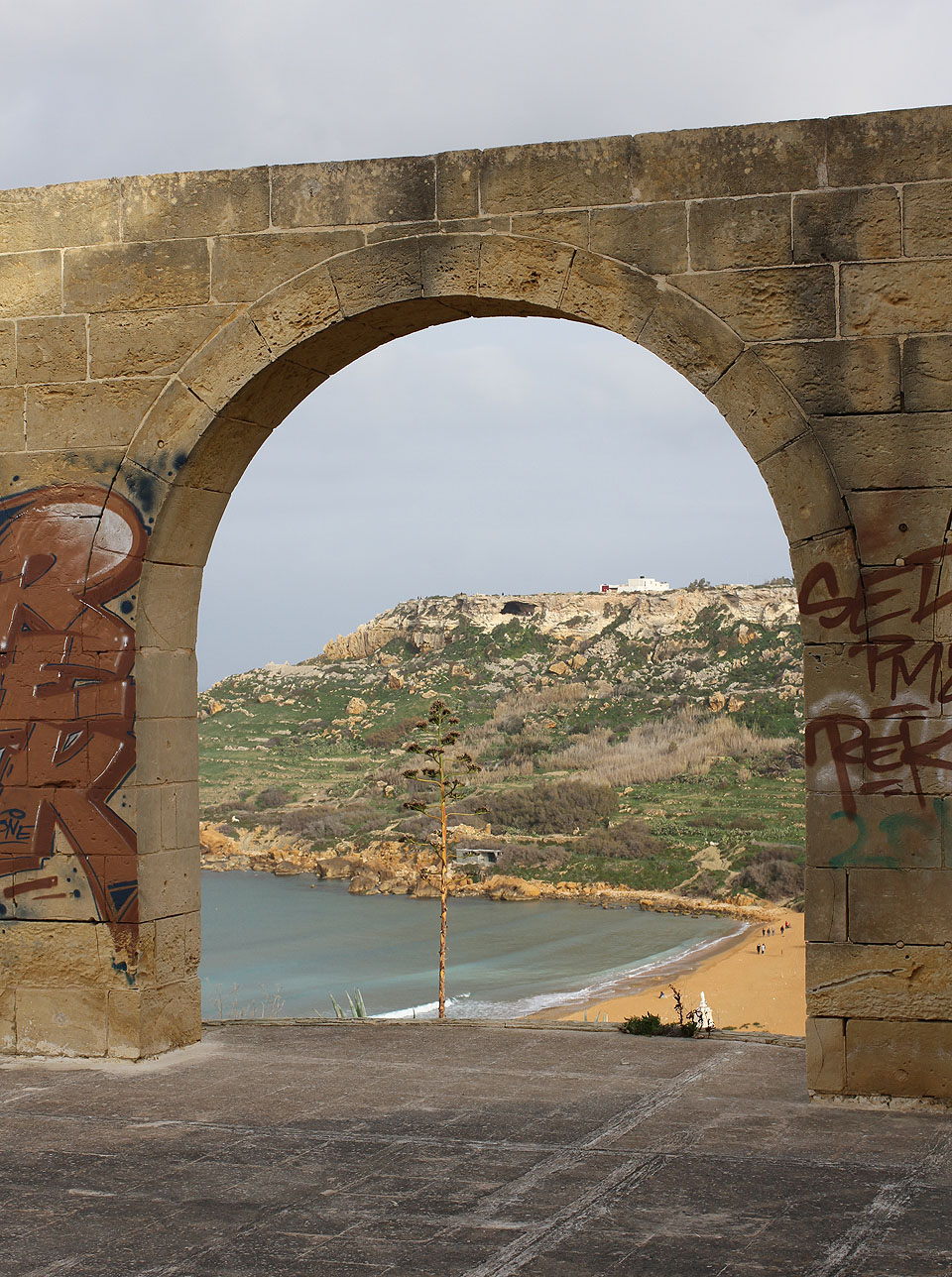 Pohled na protější stranu zátoky, ve skalách se jasně rýsuje jeskyně Mixta.