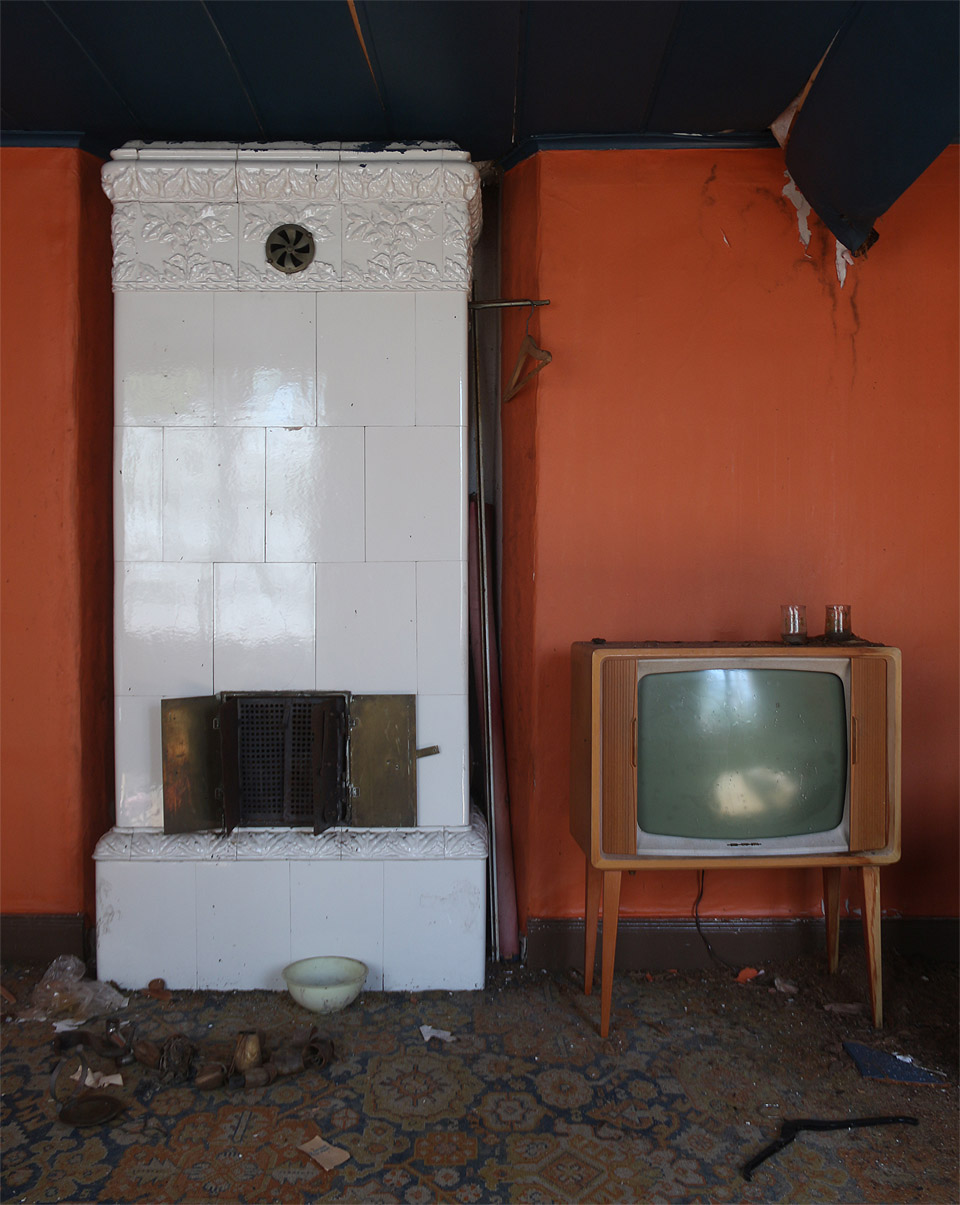 Nádherné setkání generací: kachlová kamna, za která by se nemusel stydět lecjeden chudší venkovský šlechtic, a moderní televizor v uzavíratelné dřevěné skříňce.