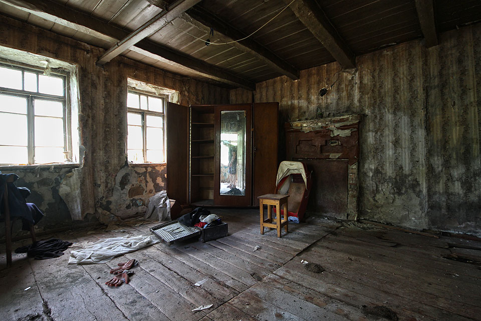 Obytná jizba polosuterénního patra byla zařízena skromně. Vpravo od skříně je vidět zbytek otevřeného krbu, který sloužil k vytápění místnosti.