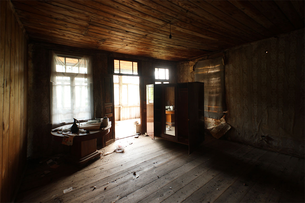 Hlavní jizba prvního patra je cele obložená dřevem, které hezky voní i barví světlo pronikající částečně zabarikádovanými okny.