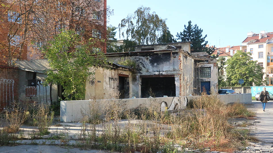 Jednou z takových pozůstalých trosek je původní rozvodna továrny, ukrytá ve stínu stromů a paneláků v těsné blízkosti původní vrátnice z Veletržní ulice.