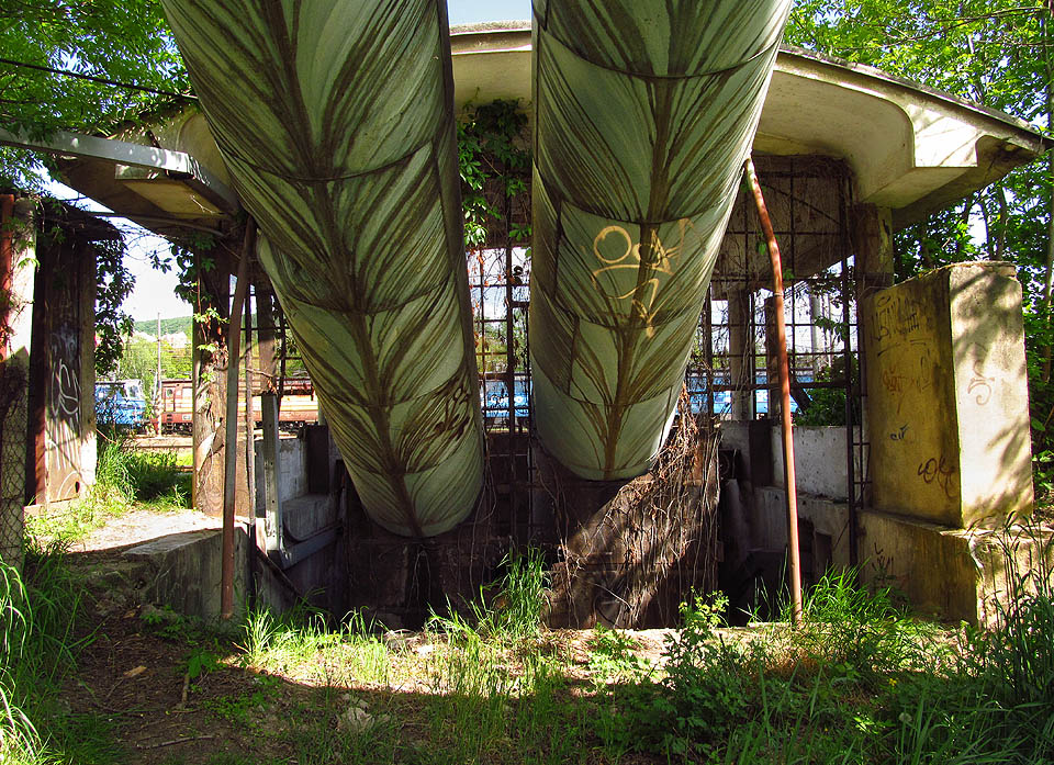 Praménky vody stékající z potrubí vytváří na zeleném plášti secesní obrazce. Nakonec stejně skončí v podchodu.