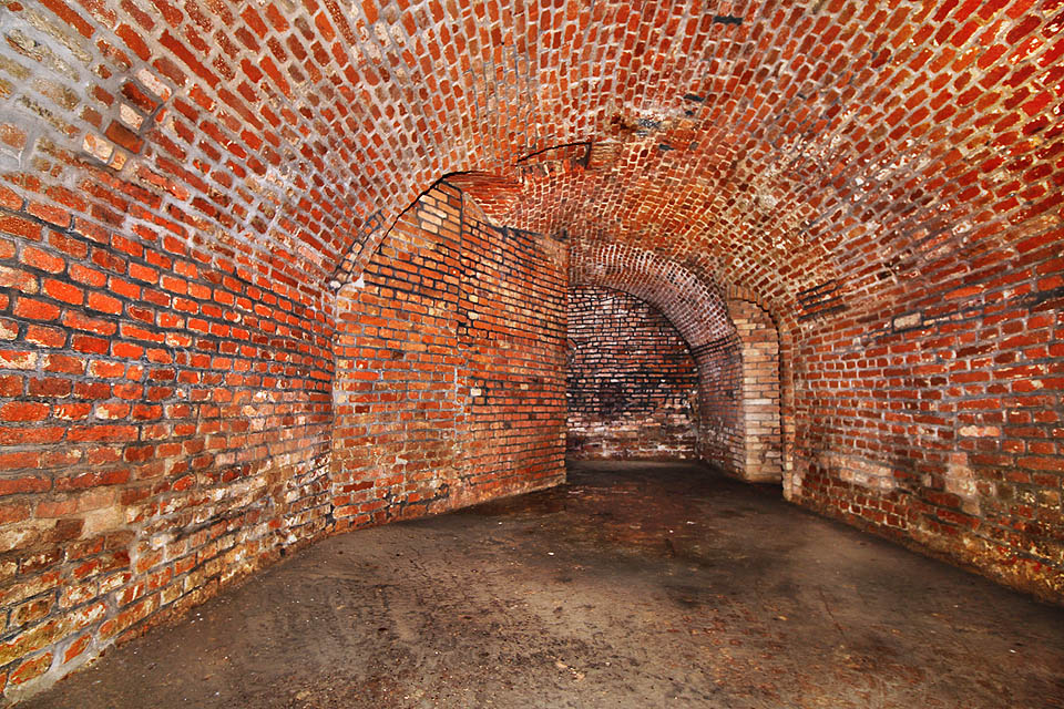 Pohled zpět do největšího - severního sálu. Vpravo je vidět přístupová chodba z nově proražené šachty, vlevo nárožní základová zeď domu U tří kohoutů.