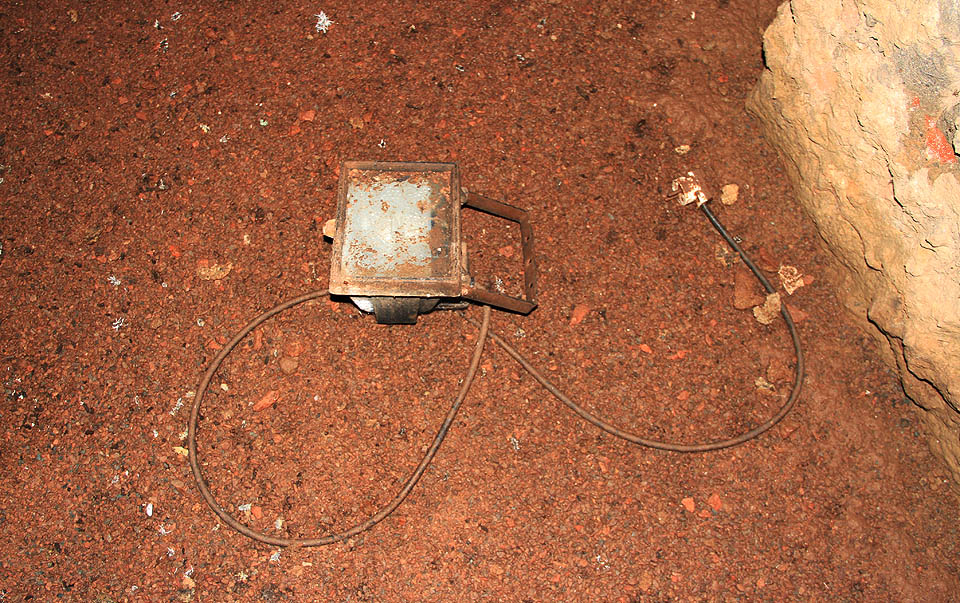 Několik náhodně pohozených reflektorů vyvolává dojem, jako by restaurátoři ze sklepení prchali před přívalem bahna z potrubí ve zběsilém zmatku.