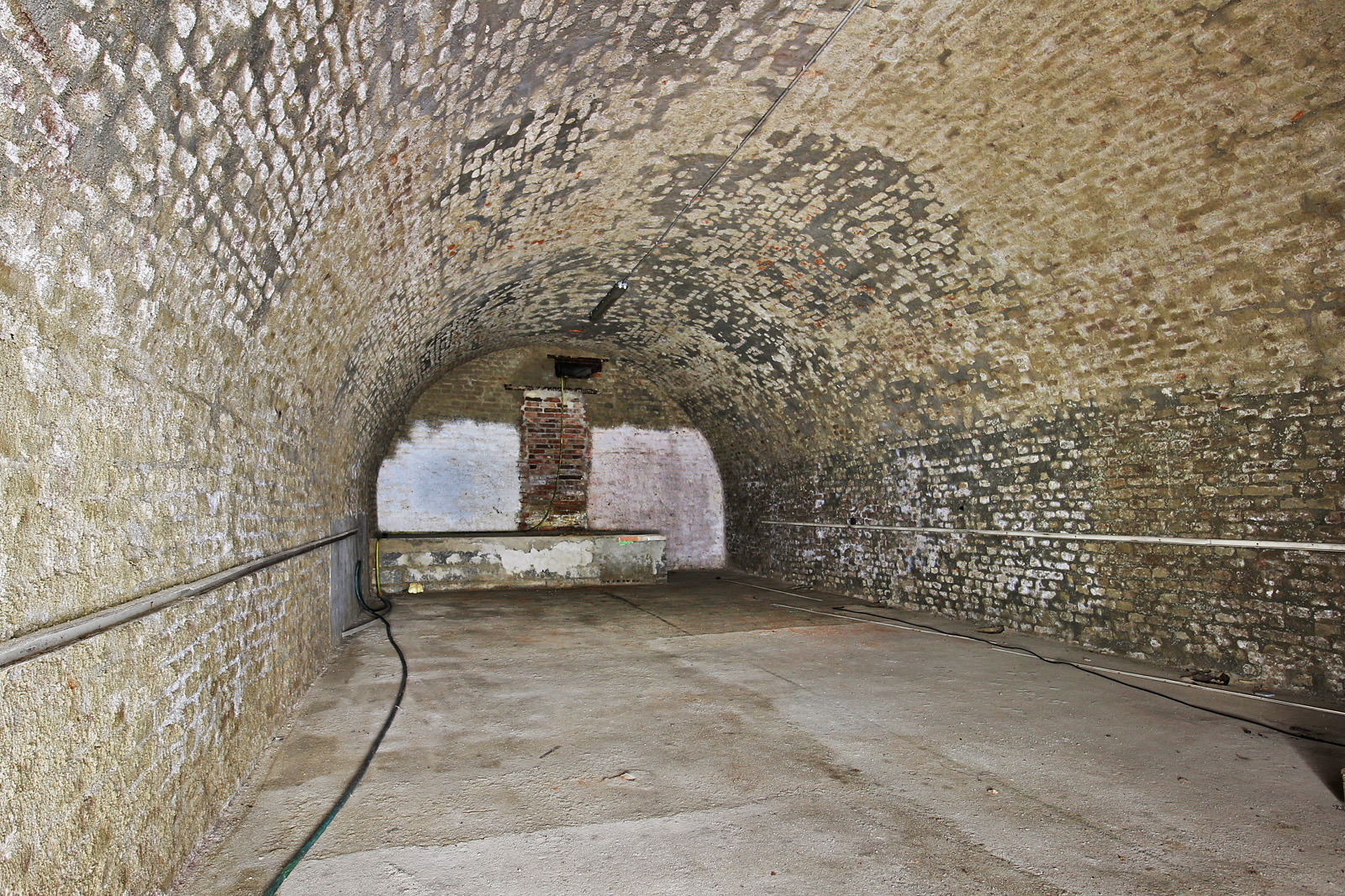 Poslední místnost sklepa směrem do svahu končí stěnou se zazděnými dveřmi. Na druhou stranu ovšem lze proniknout buď jakýmsi okénkem, proraženým u stropu nebo „podzemím pod podzemím“ ukrytým pod pódiem či podestou nejasného významu. Za stěnou se pak nachází rozměrná šachta vedoucí k povrchu zemskému.