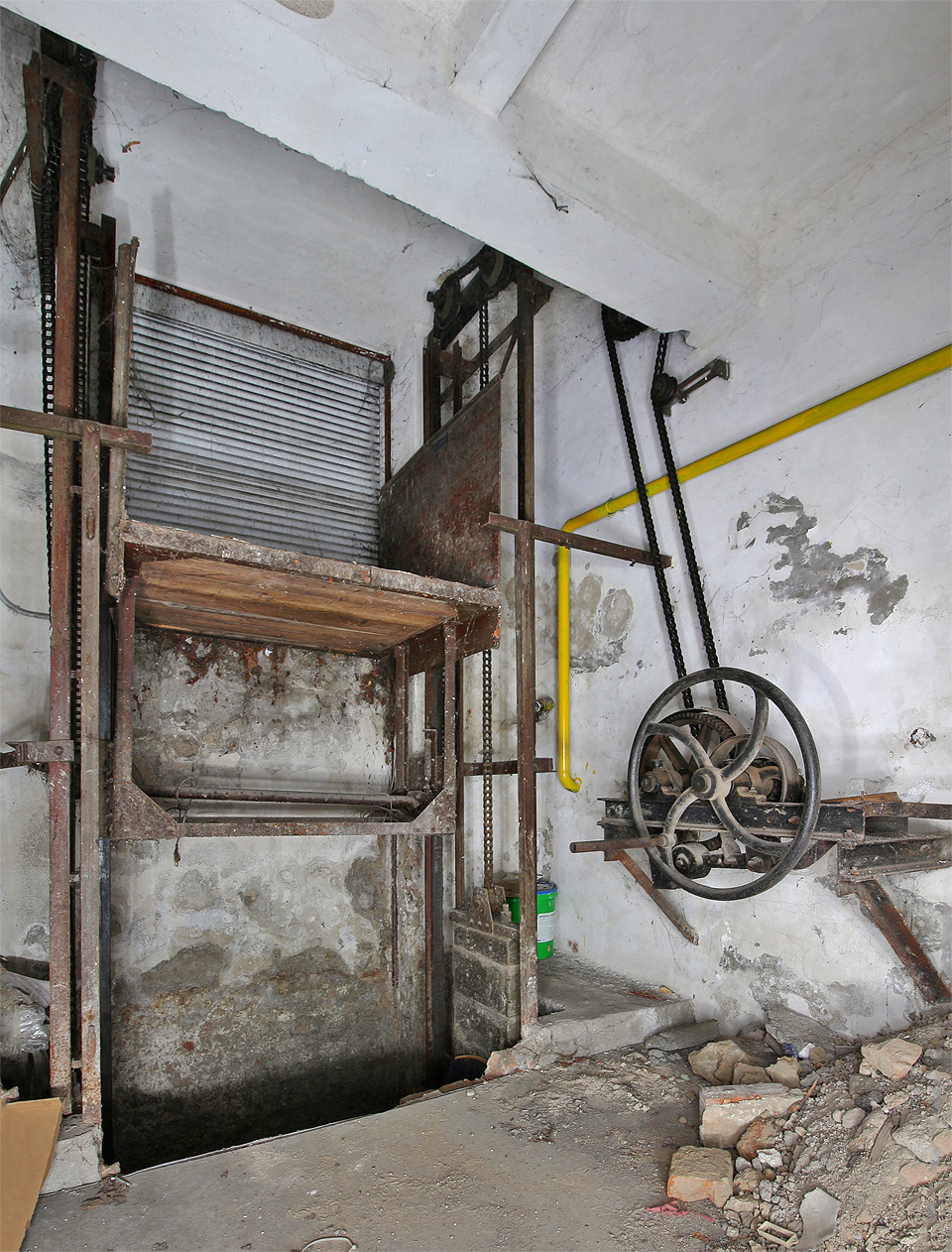 Ruční výtah pochází zřejmě z počátku 20. století. Za (žel již renovovanou) roletou se nachází ulice Hlinky.