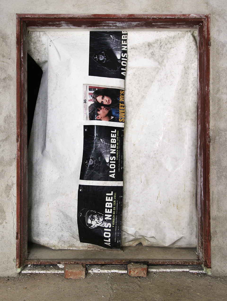 Tepelné a vlhkostní podmínky ve sklepě reguluje mimo jiné tato záclona z plakátů zvoucích na film Alois Nebel v roce 2011.