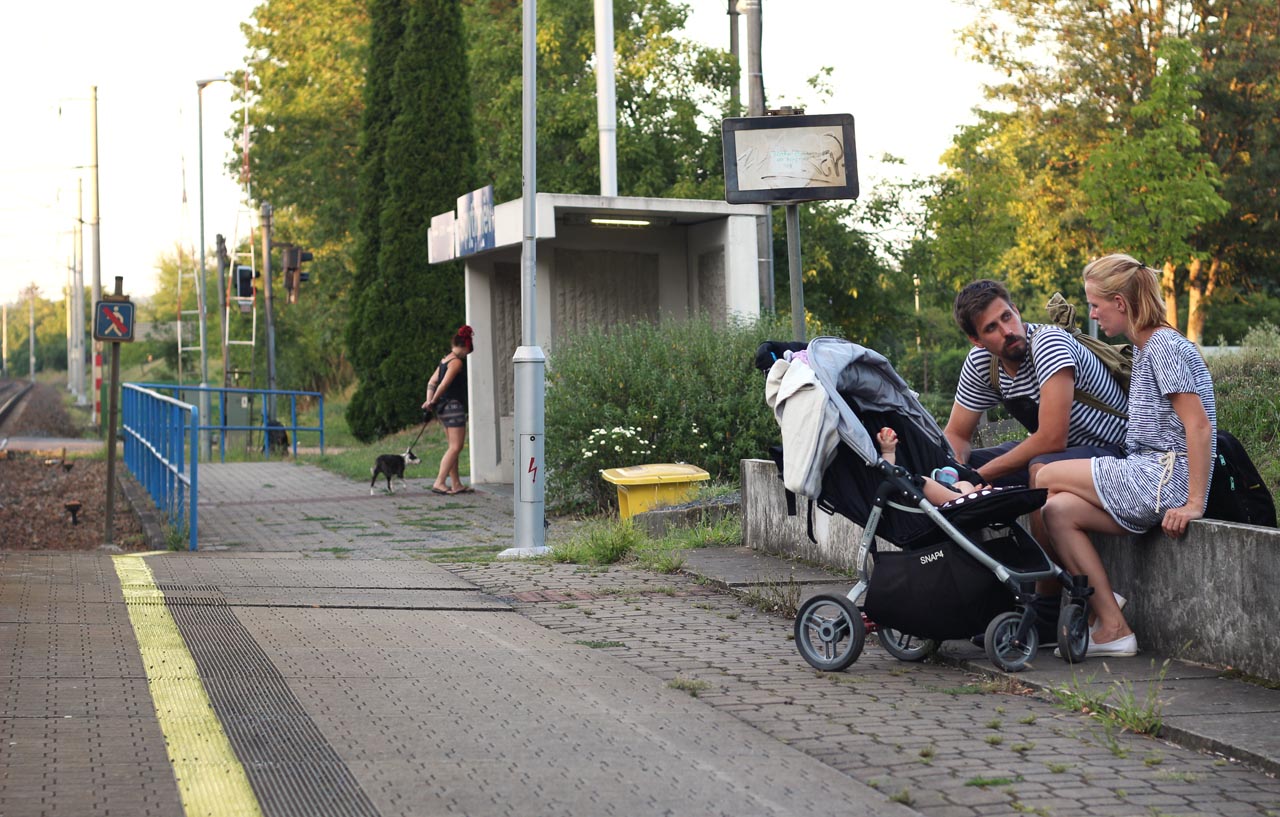 Mladí rodiče, dítě, dívka a pes na zastávce ve Spytihněvi.