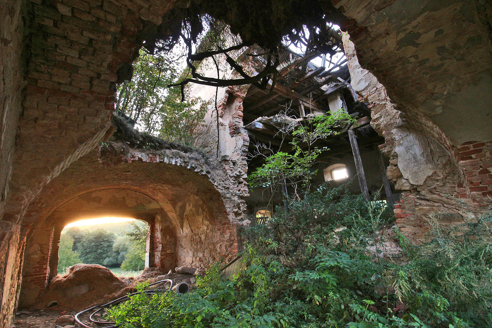 Zhruba ve středu průčelí obráceného k západu se nacházel průjezd do dvora. Nad ním se před propadnutím kleneb nacházela obytná část statku.