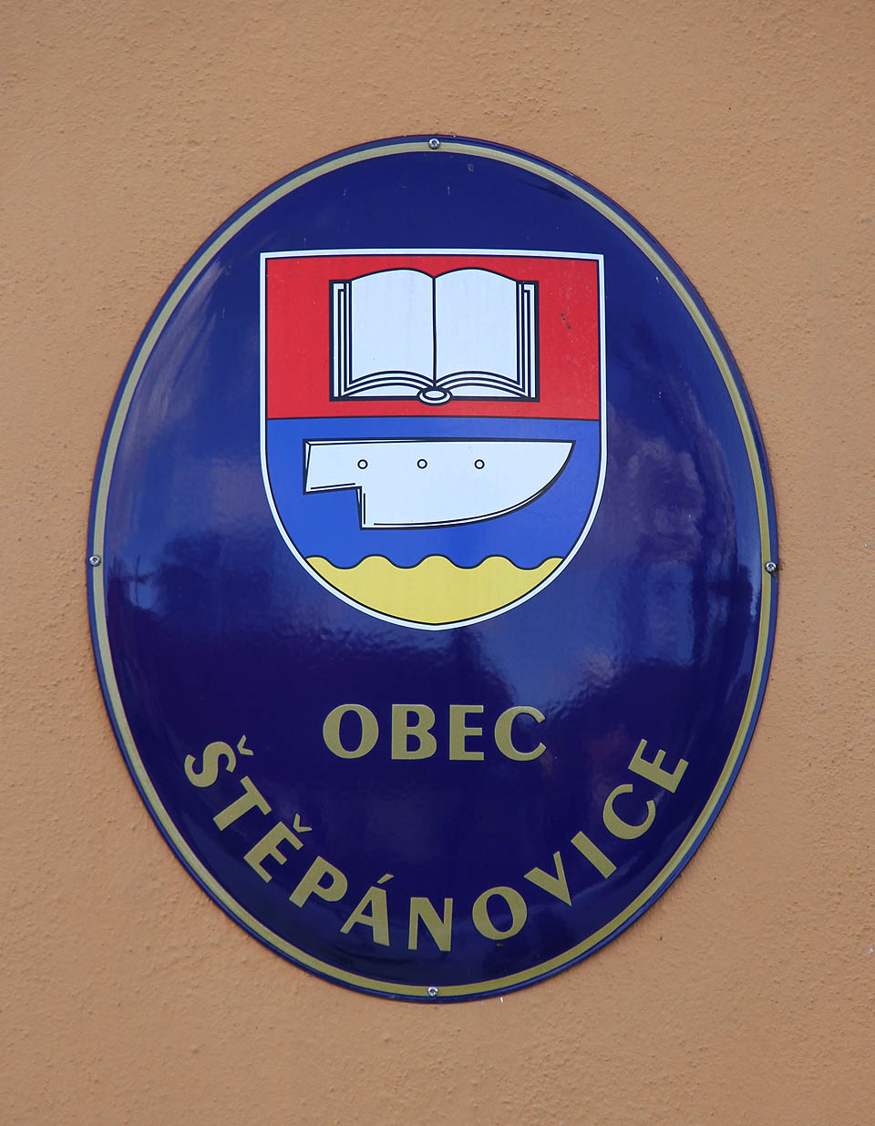 Znak Štěpánovic na eliptické smaltované tabuli obecního úřadu.