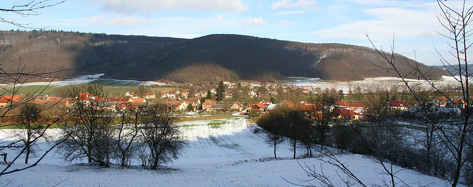 Pohled na dvě části Štěpánovic od jihozápadu z kopce Dranč. V popředí starší část obce rozvinutá po pravém břehu řeky Svratky, ve vzdálenější části údolí novější, levobřežní část obce.