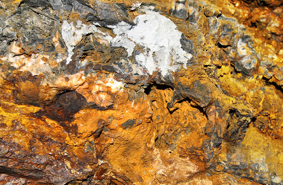 Železité nerosty jsou na vápencovém? podkladu dobře patrné. Všechny odstíny rzi od citrónově žluté až po tmavě rudou jsou tady doma, propletené navíc bělostnými křemennými? žilkami.