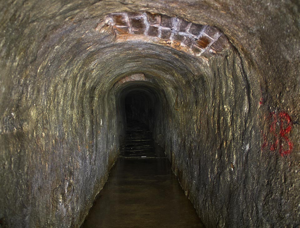 Betonová vrstva se místy loupe, sintrové nánosy na podlaze se noří do vody.