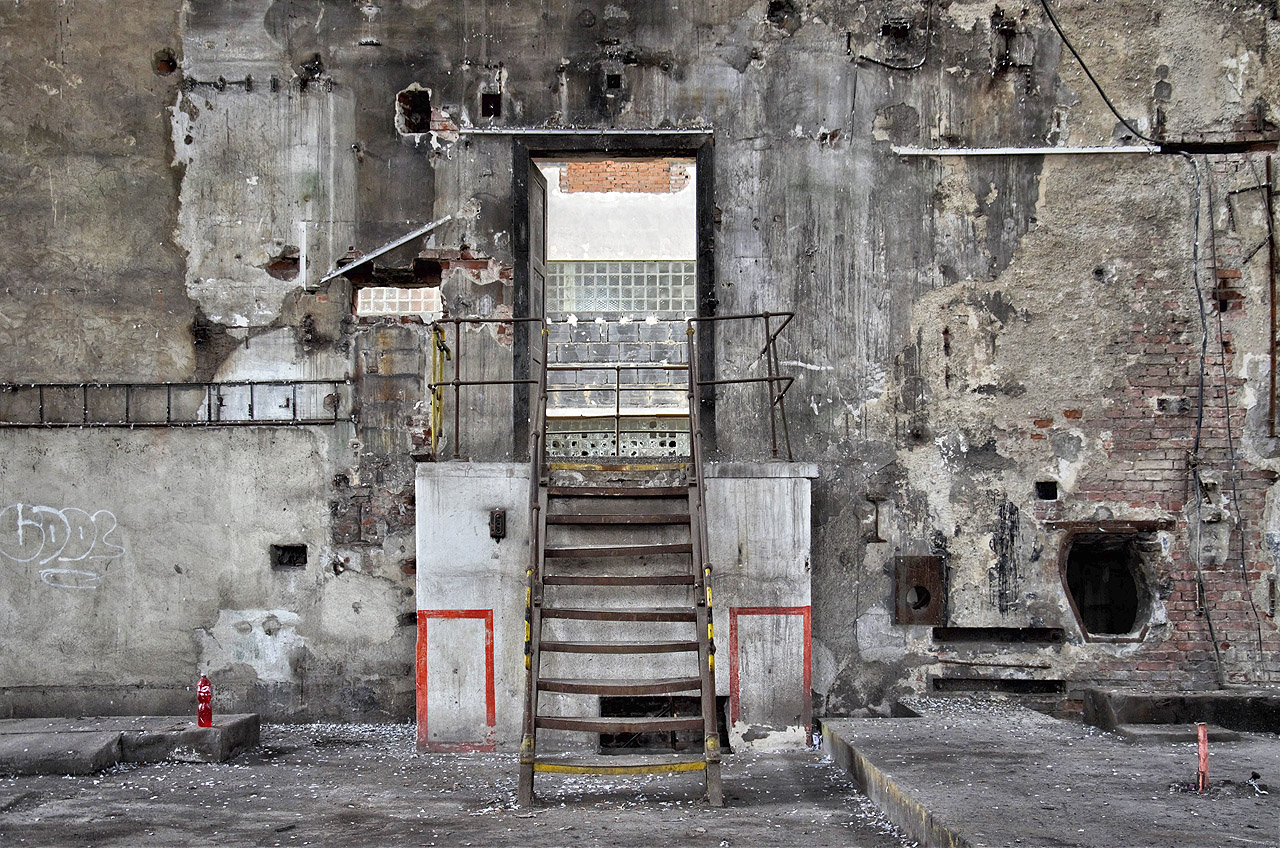 Jednoduché ocelové schůdky vedou z výtopny do strojovny, kde se nacházely generátory. Opouštíme zapopelený provoz a přecházíme do čistší haly, vonící olejem.