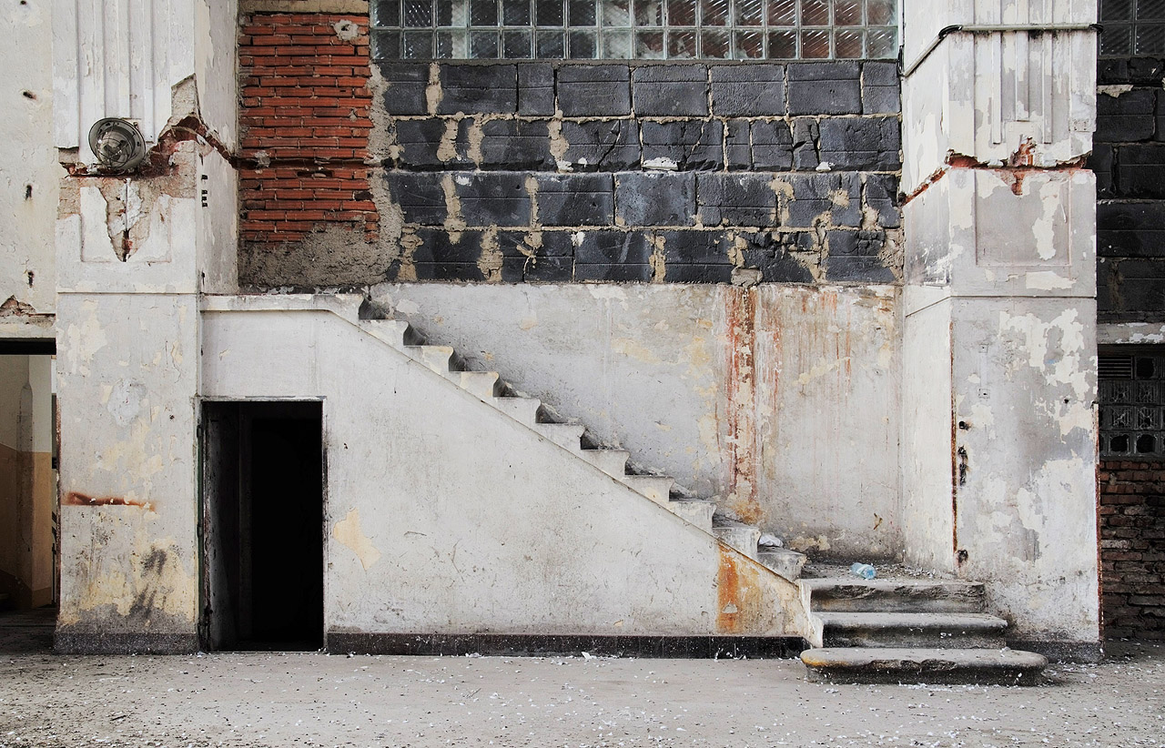 Směs secesních štuků sloupoví, ryze technických materiálů a socialistických luxfer dokresluje marnost zbytečného schodiště, které snad kdysi vedlo do velína, jež dávno pozbyl svůj význam. Tady už není komu ani čemu velet…