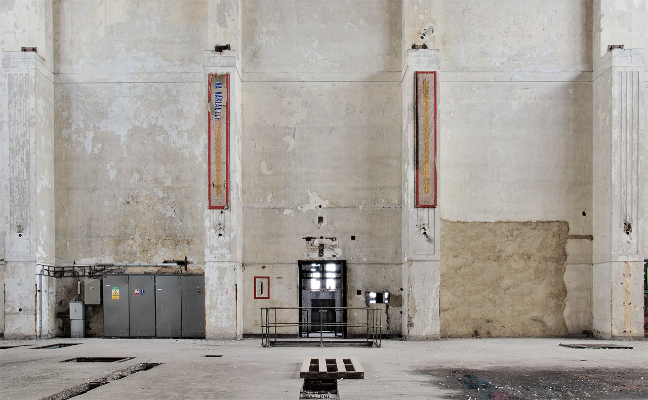 Skrze transparent nejasného stáří se nám kdosi snaží sdělit snad, že na nákladech závisí úspěšnost podnikání severomoravských elektráren. A nebo něco jiného? Z hloubi se ku povrchu klubou ozdobné kytice a nedořčená věta už navždy zlstane zahalena tajemstvím.