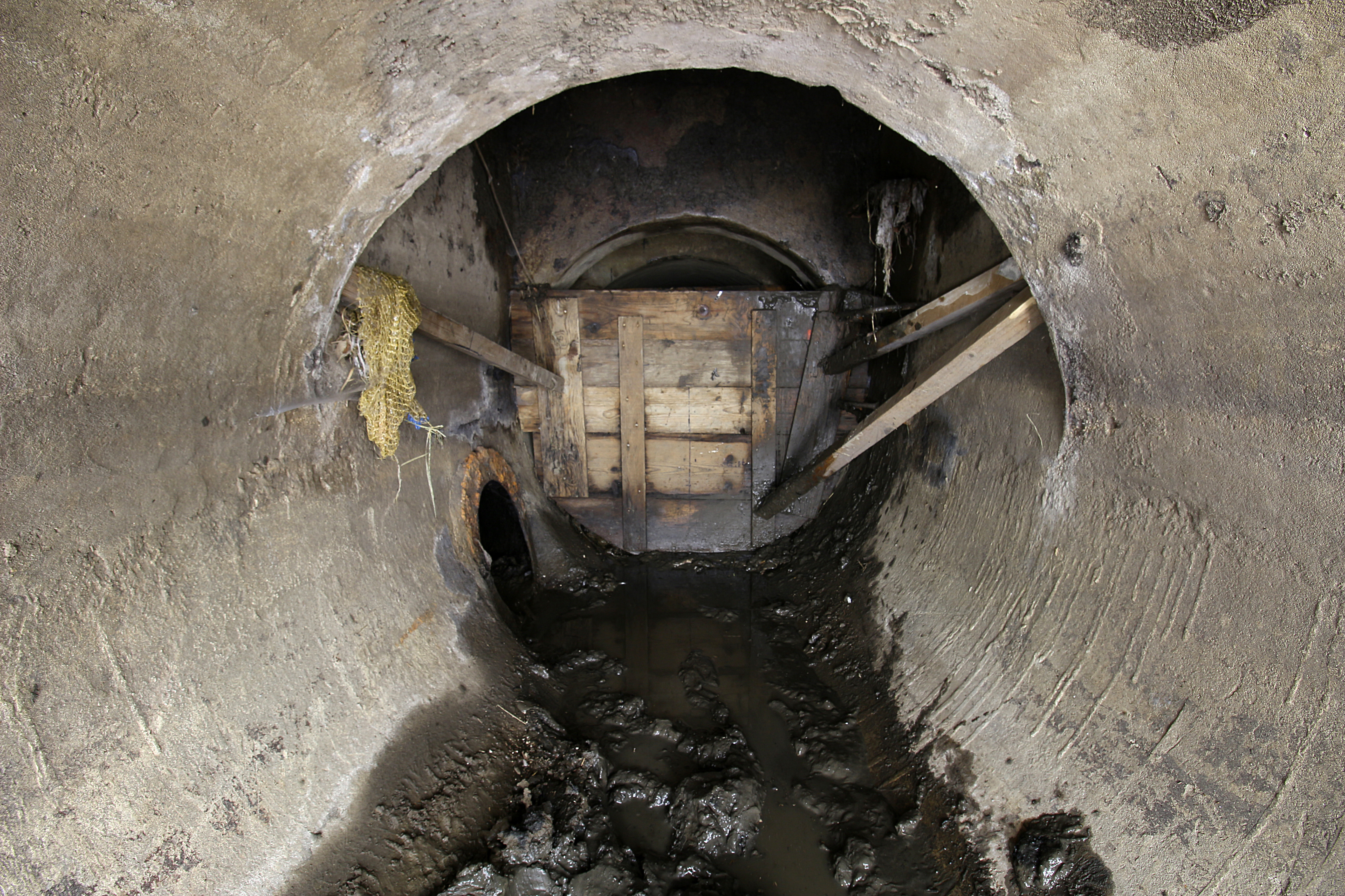 Tak vypadá závěrečná pasáž pod svitavským nábřežím. Rourou vlevo odtéká voda pod jez, dřevěná bariéra a pytle s pískem za ní oddělují stoku od hladiny řeky nad jezem. Jde nejspíš o pozůstatek po povodni ze září 2024, který dosud nebyl odstraněn a díky tomu se ve štole drží poměrně dost smrdutého bahna. Tak vypadá závěrečná pasáž pod svitavským nábřežím. Rourou vlevo odtéká voda pod jez, dřevěná bariéra a pytle s pískem za ní oddělují stoku od hladiny řeky nad jezem. Jde nejspíš o pozůstatek po povodni ze září 2024, který dosud nebyl odstraněn a díky tomu se ve štole drží poměrně dost smrdutého bahna.