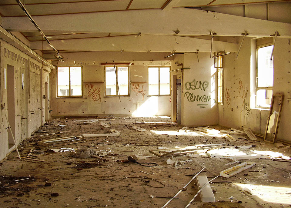 Také v této místosti poničené z podivné touhy návštěvníků po destrukci je vidět postupné přistavování budov. Původní vnější zeď haly s cihlovými ornamenty vlevo je zakrytá socialistickou přístavbou s betonovými nosníky.