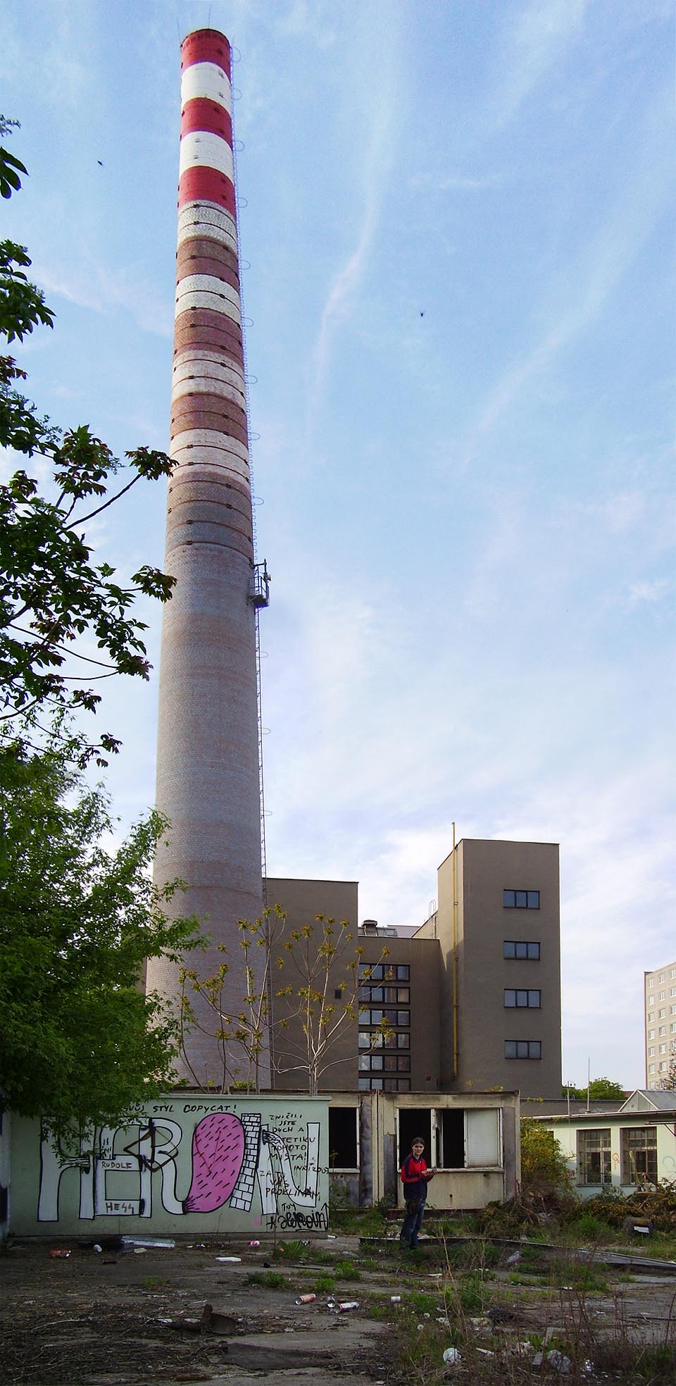 Ve vyrabovaných stavebních buňkách přebývali nejrůznější obyvatelé. Třeba vyděšená děvčata bez dozoru. V pozadáí je komín teplárny, který jako jediný z trojice komínů přežil, protože nebyl součástí továrny.