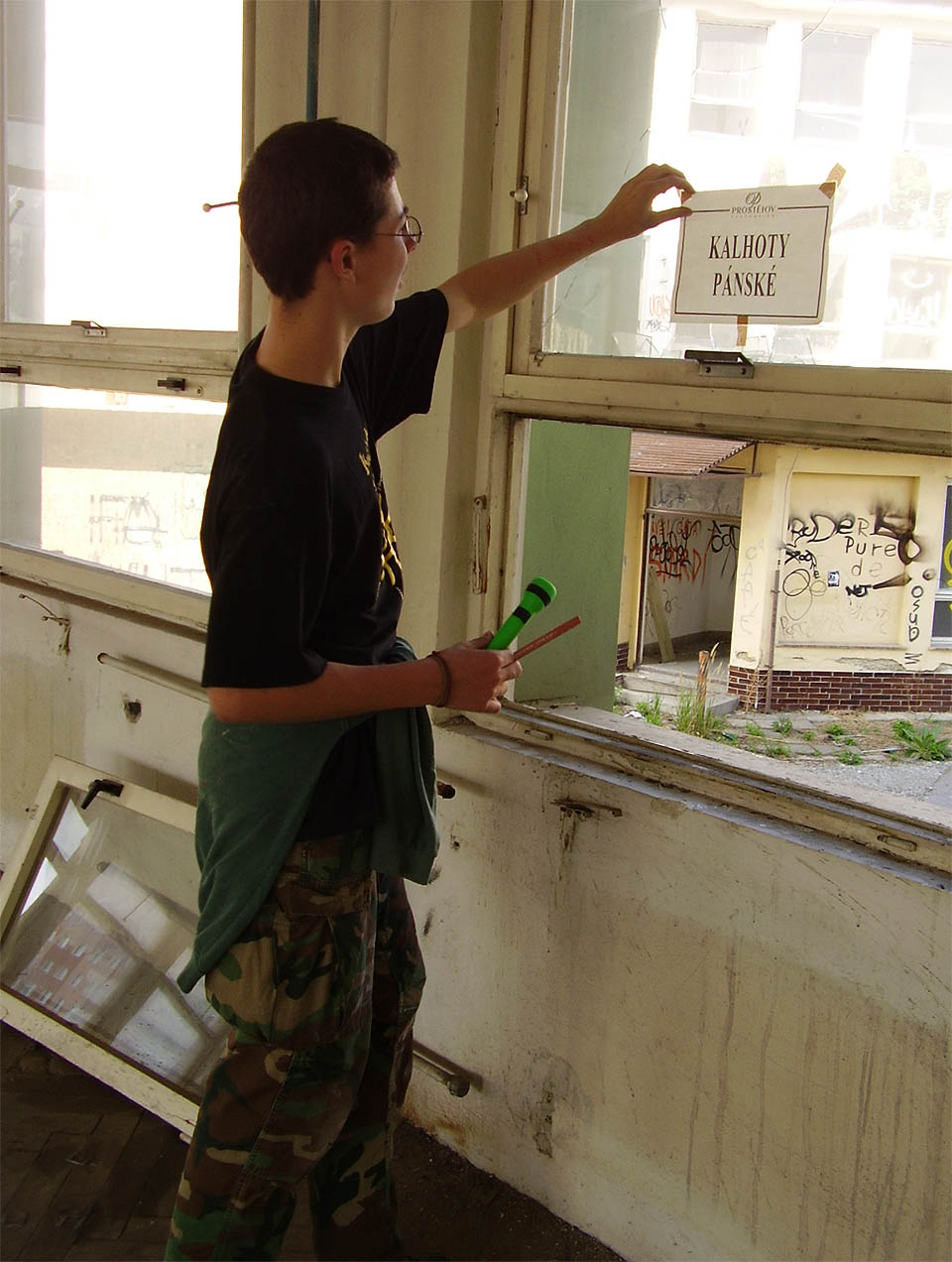 V poslední fázi svého života sloužila textilka Kras také jako místo konání výprodejů z kolabujících českých oděvních podniků. Kolega na snímku odlepuje cedulku s logem OP Prostějov.