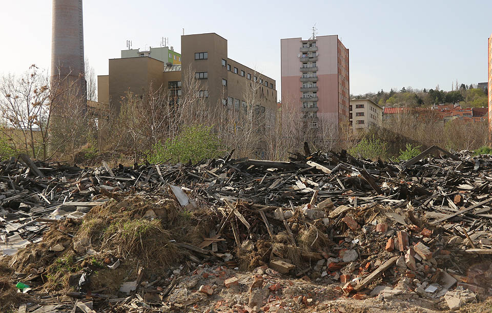 Tak vypadlo místo, kde komín stál, na jaře roku 2018. Možná, že některé z cihel na hromadě pochází z jeho štíhlého pláště.