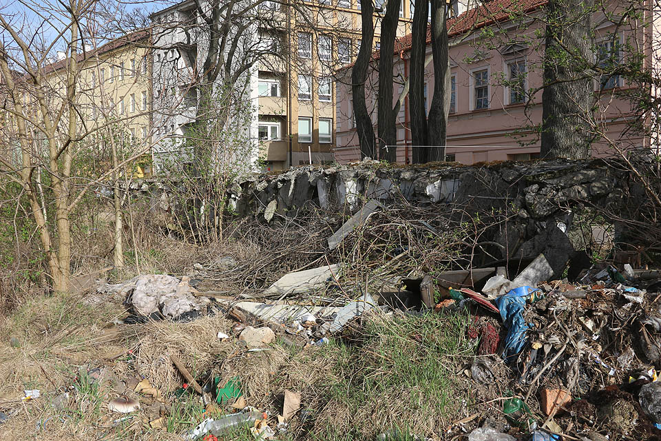 Zeď do ulice Bělidla postupně mizí pod horami odpadků. Opuštěný areál slouží k odhazování bezpečných i nebezpečných odpadů kdekomu. Místním firmám, obyvatelům, bezdomovcům i kolemjdoucím. Je to taková studie do hloubi české duše.