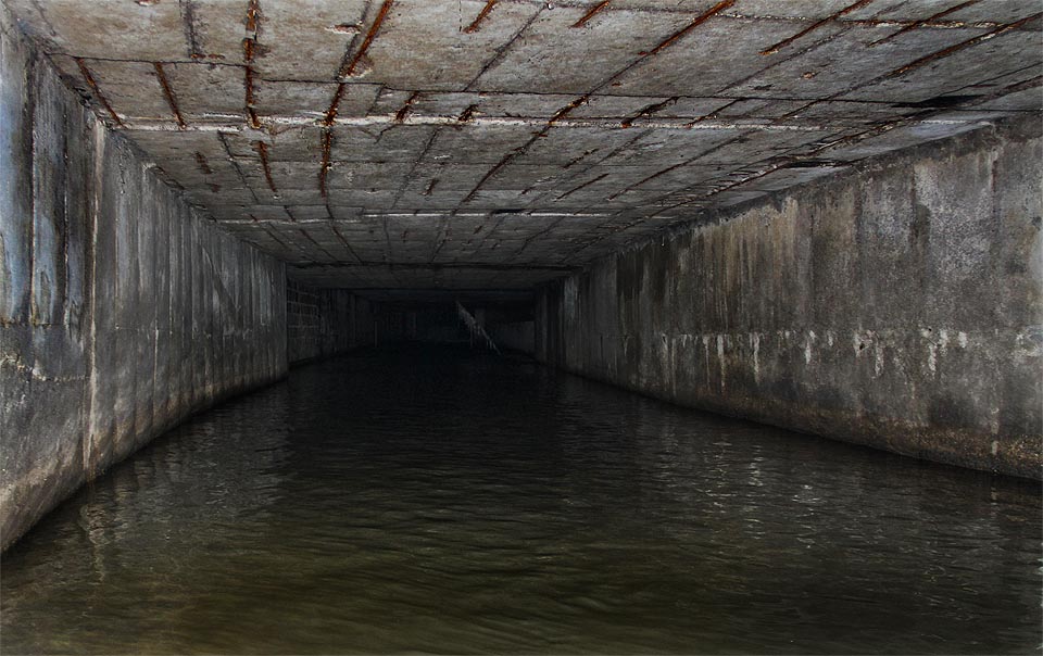 Za dalším záhybem tunelu již  cosi probleskuje. Nejprve se nám zdá, že jde o okna domů nad tunelem viditelná skrze česle, vzápětí ale zjišťujeme, že jsme hluboko pod zemí a byly to jen odrazy.