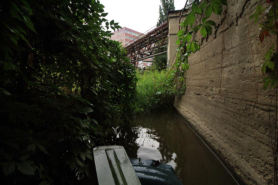Zdá se až neuvěřitelné, že v těchto místech, kde náhon protéká v betonovém korytu industriální spletí potrubí, kolejí a dopravníků, stávaly kdysi výstavní zahrady ve francouzském stylu.