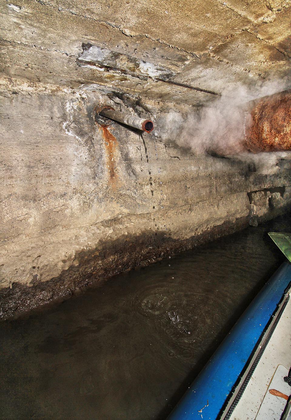 Už zdálky slyšíme ve druhém tunelu tajemné nepravidelné syčení a bublání. Za rezavou rourou, pod kterou se musíme poklonit, spatříme jeho zdroj. Ze zdi trčí krátká trubka, ze které se valí kotouče páry a do náhonu odkapává vroucí voda. Manévrovat pod ní bezpečně s lodí je nemožné a Honza si z dobrodružné cesty odváží slušné opařeniny.