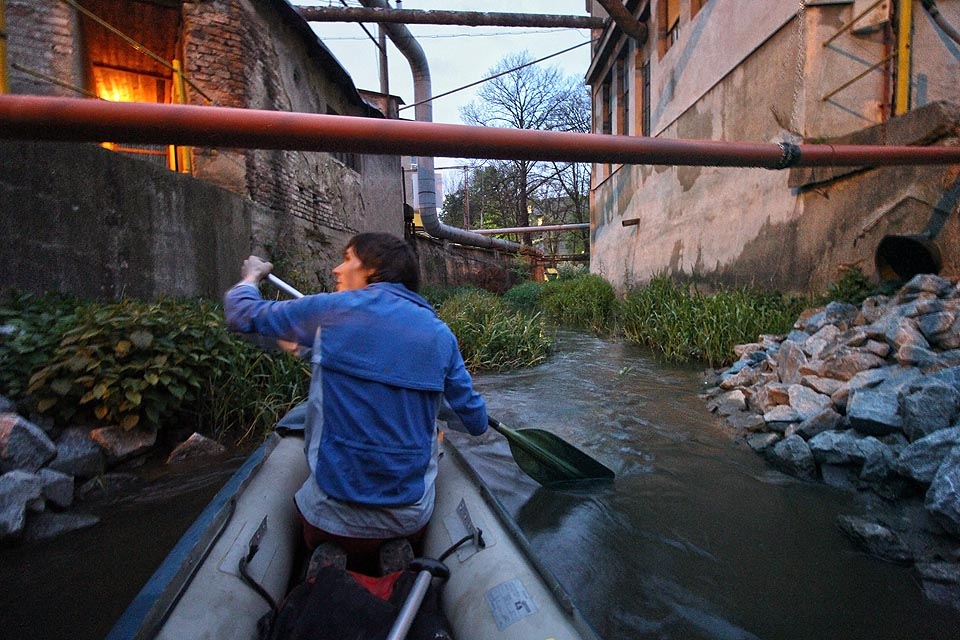 Uvnitř Mosilany proud opět zrychluje a unáší nás pod již uzavřeným areálem mezi temnými tlamami litinových rour a česlemi před náhony k dávno zaniklým trubínám.