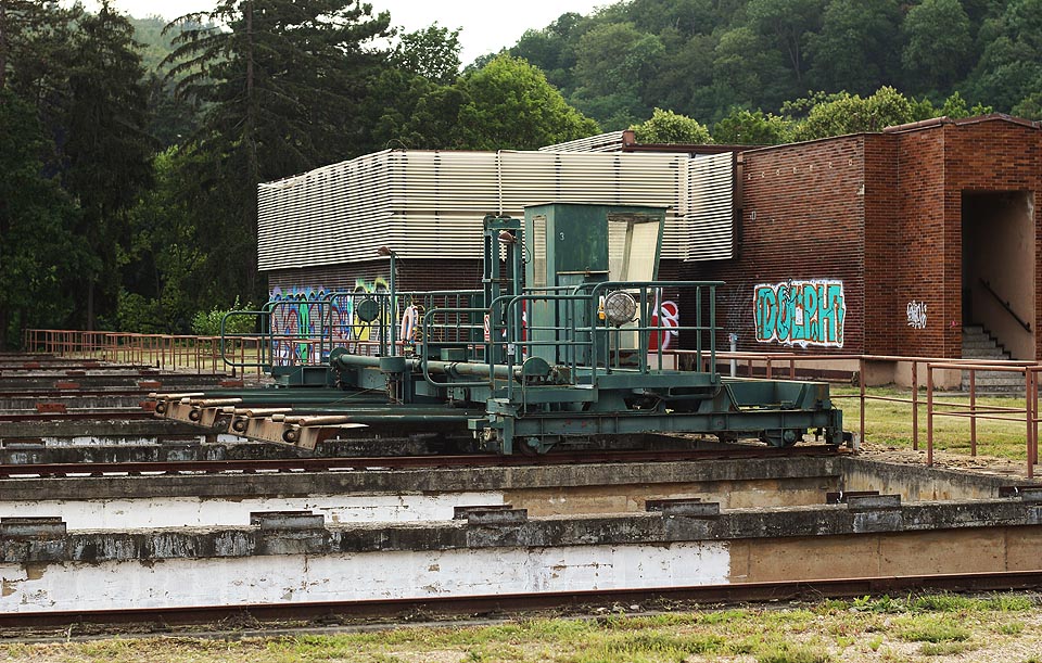 Pojízdný shrabovací jeřáb mohl shrabovat usazený kal ze dna nádrží, nad kterými dovedl přejíždět v obou směrech, do kalových jímek. Po naředění byl vypouštěn z vodárny rovnou do kanalizace. V pozadí budova homogenizace a agregace.